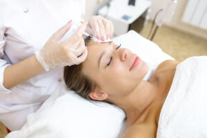 Woman receiving Xeomin injections into her forehead to smooth out wrinkles