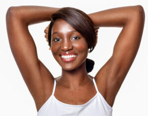 Beautiful dark-skinned woman smiling and showing her smooth underarms after getting laser hair removal