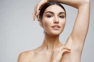 Close up of a beautiful young woman lifting her arm to show us her smooth underarm after laser hair removal
